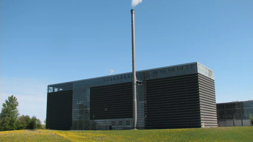 Stor sort bygning med en lang skorsten. Svendborg Kraftvarme.