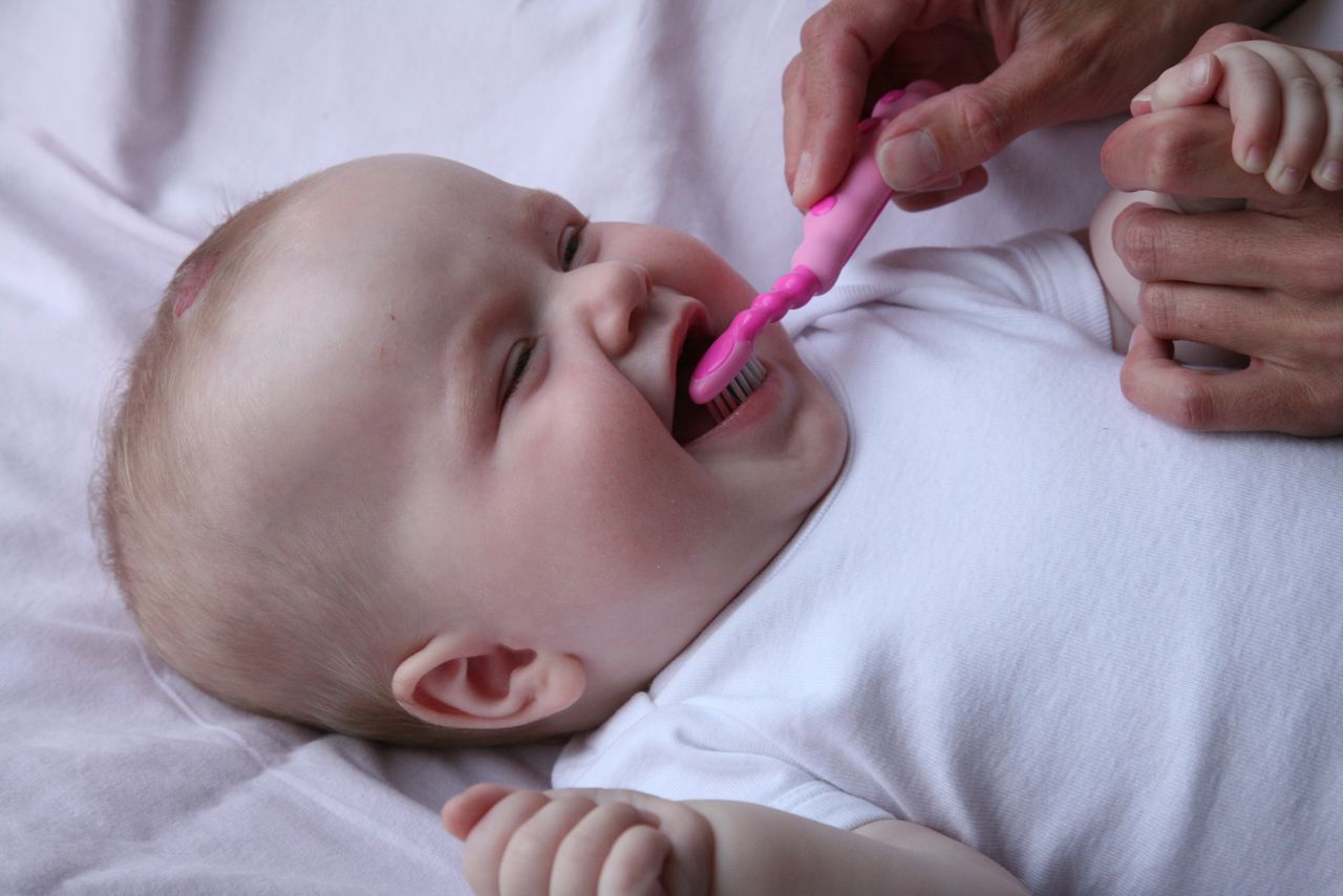 Glad baby får børstet tænder.