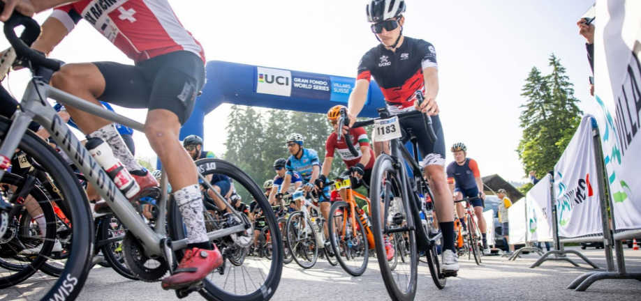 Mange cykelryttere cykler på en vej med afspærringer.