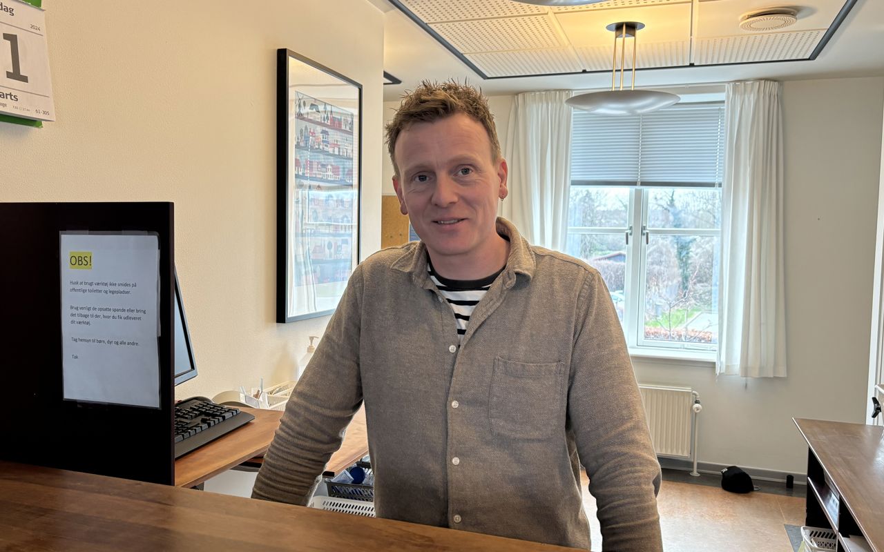 Mand står bag skranke.