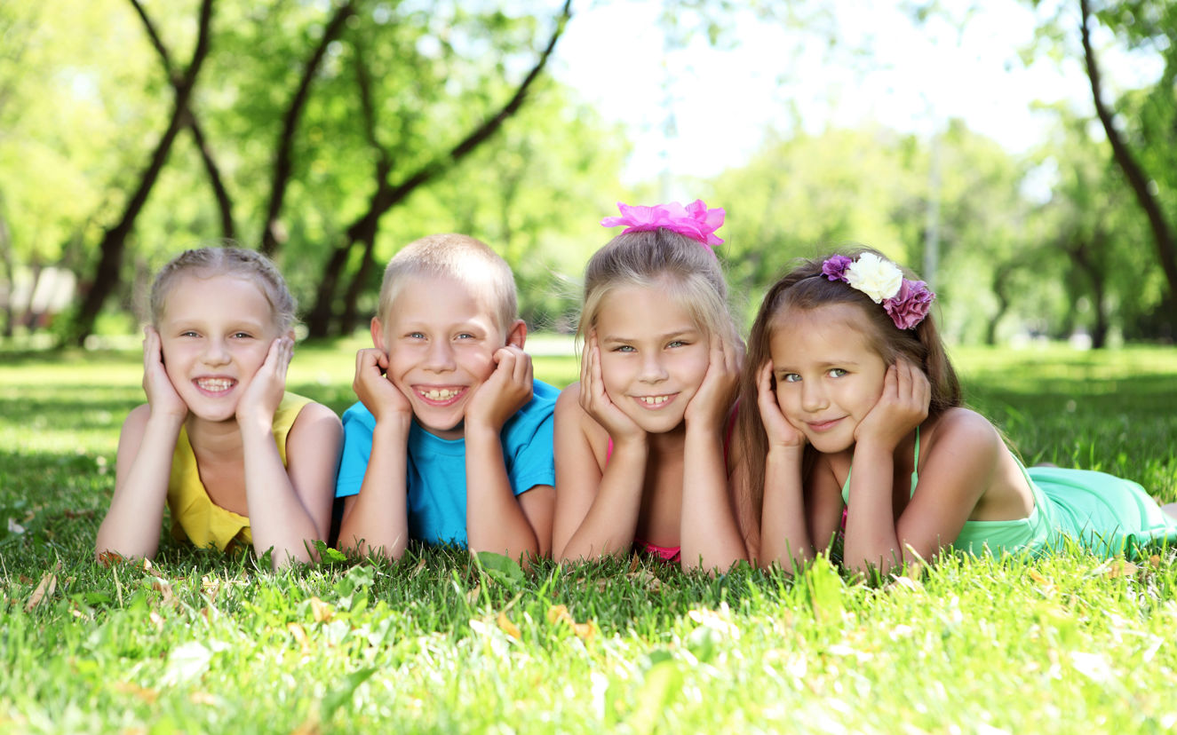 Børn der ligger på græsplænen og kigger