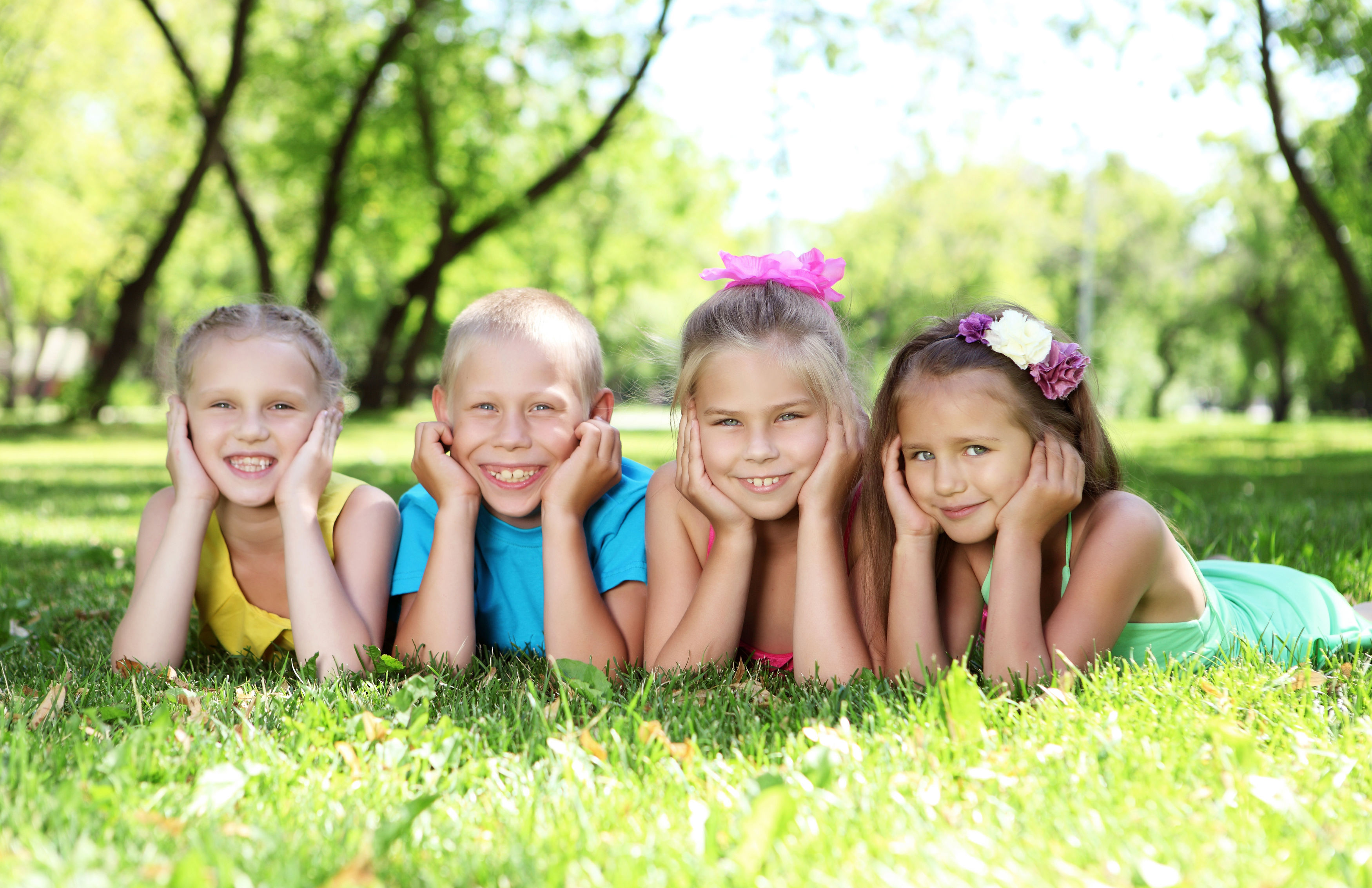 Børn der ligger på græsplænen og kigger