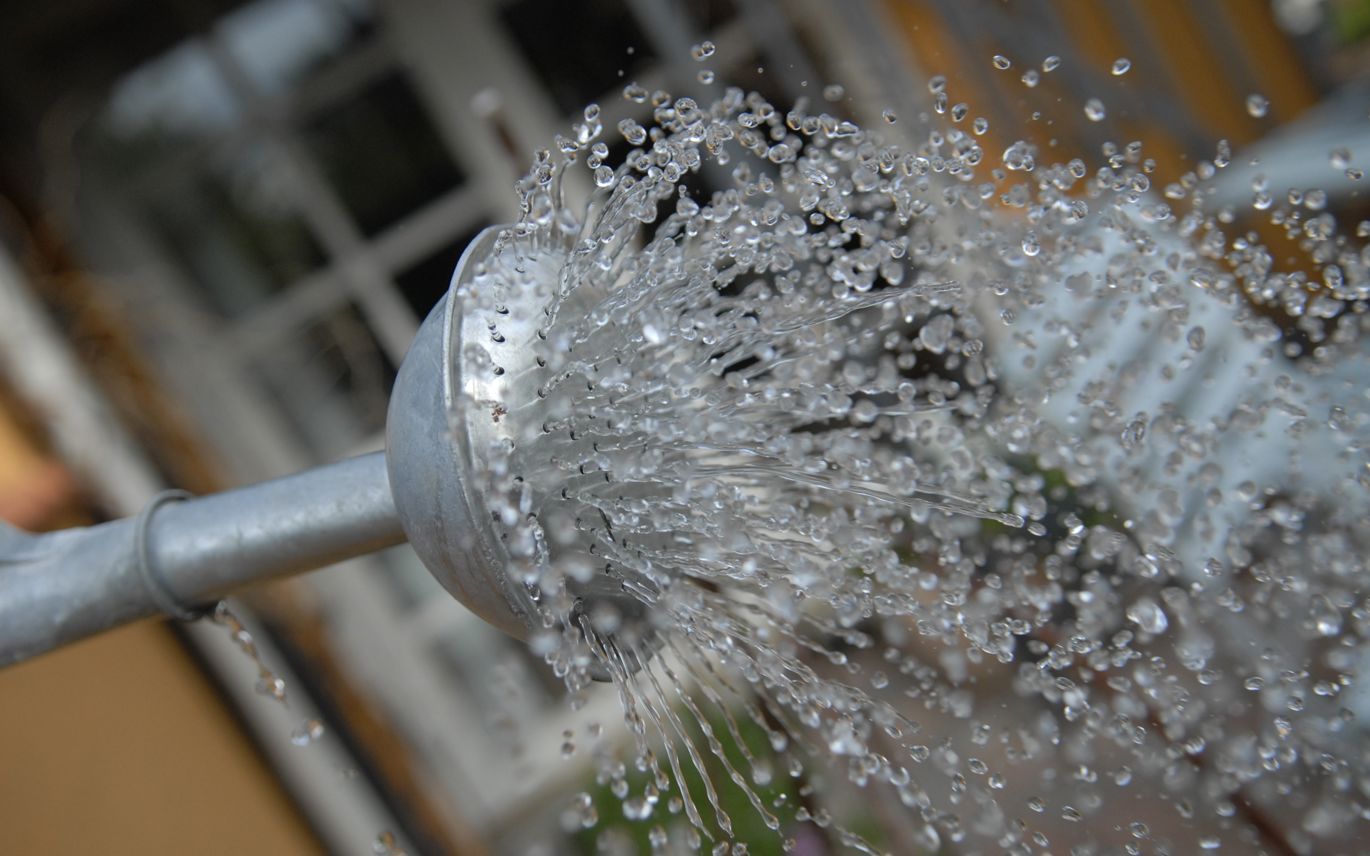 Tuden af en vandkande, hvor vandet bruser ud af