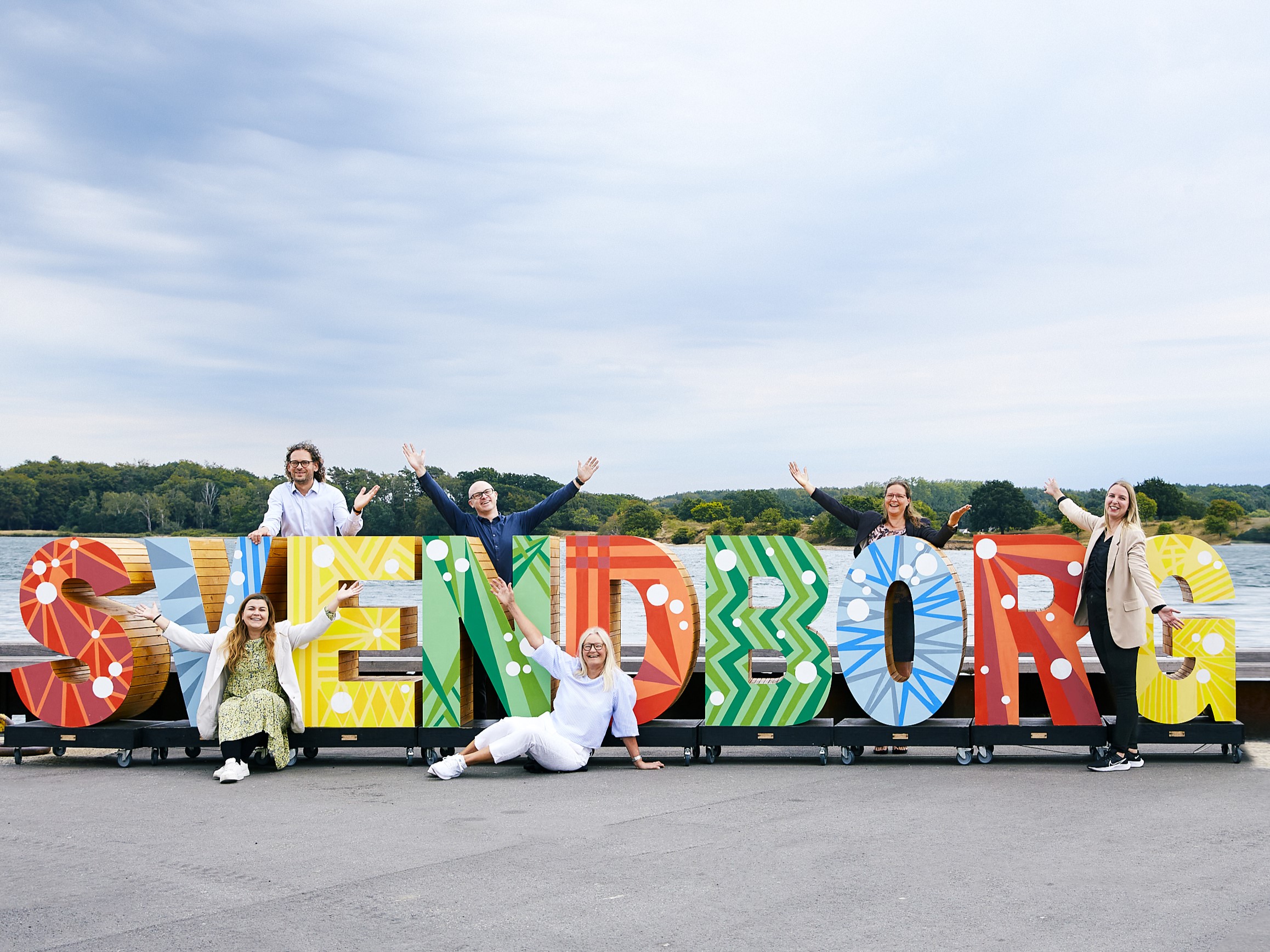 Seks medarbejdere står foran og bagved Svendborg bogstaver