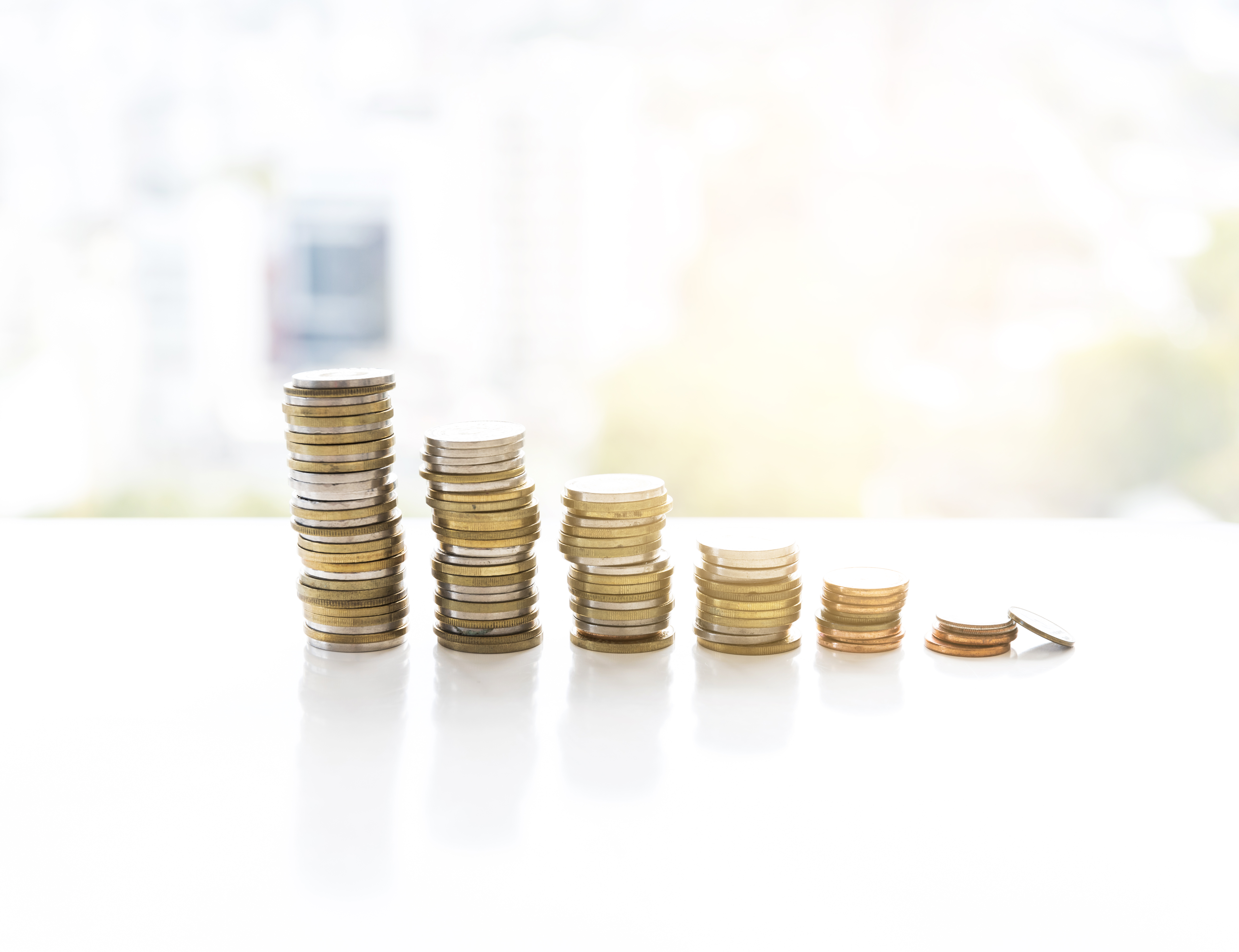 Mønter stabler i seks tårne. Tårnet til venstre er højest. De efterfølgende tårne bliver mindre og mindre.