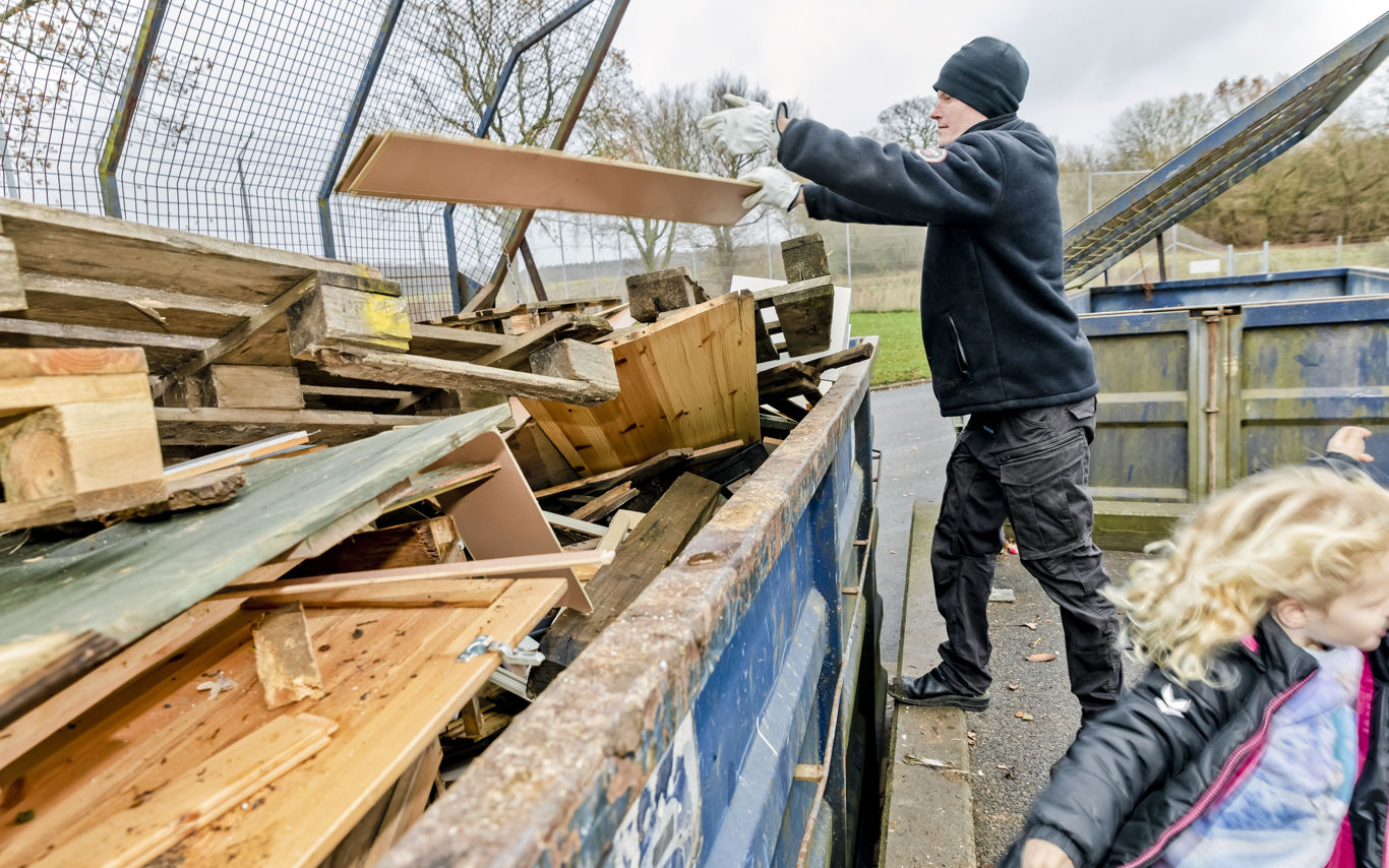 Genbrugsstationen - mand smider træ til genbrug