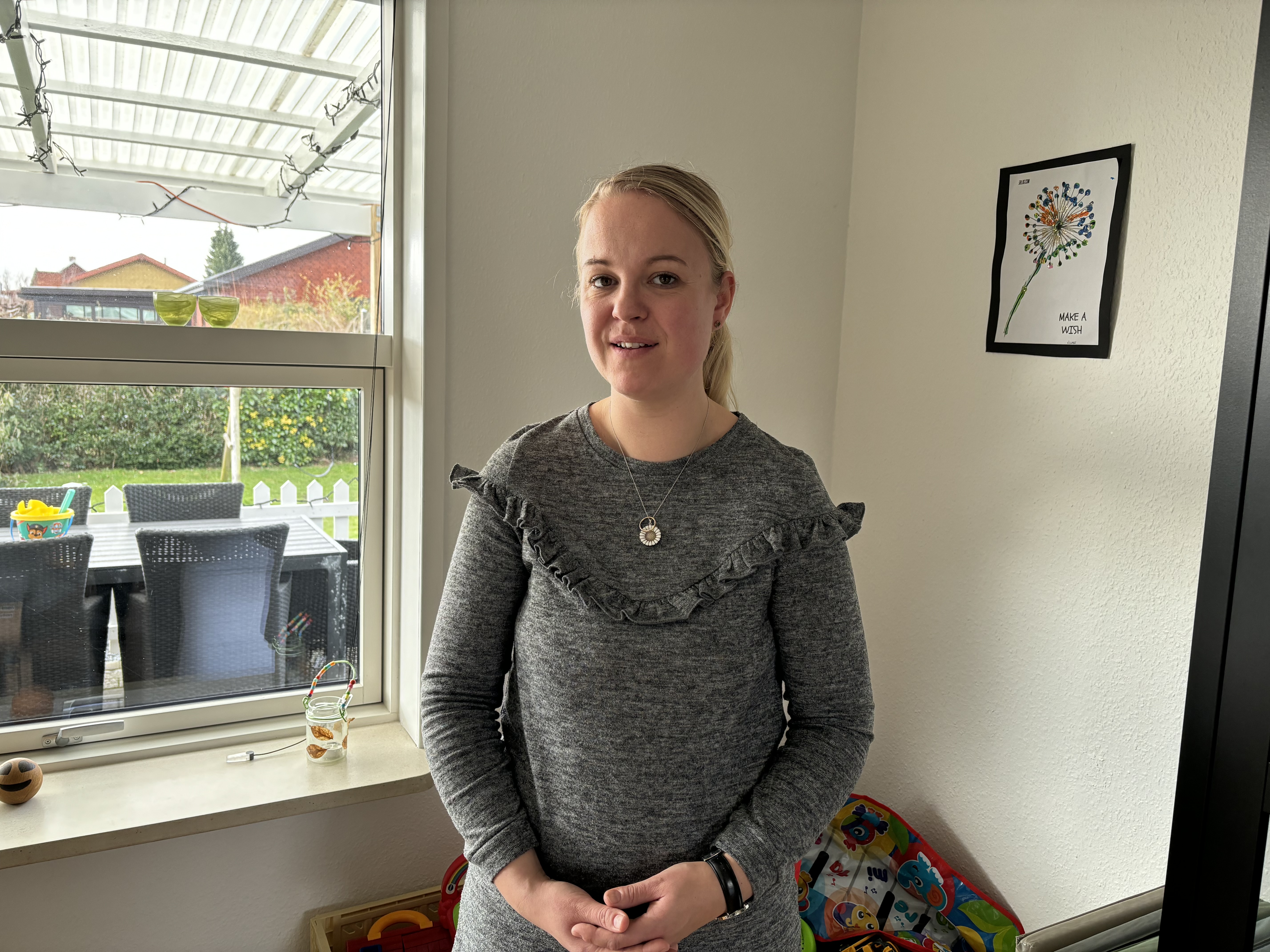 Kvinde står foran vindue