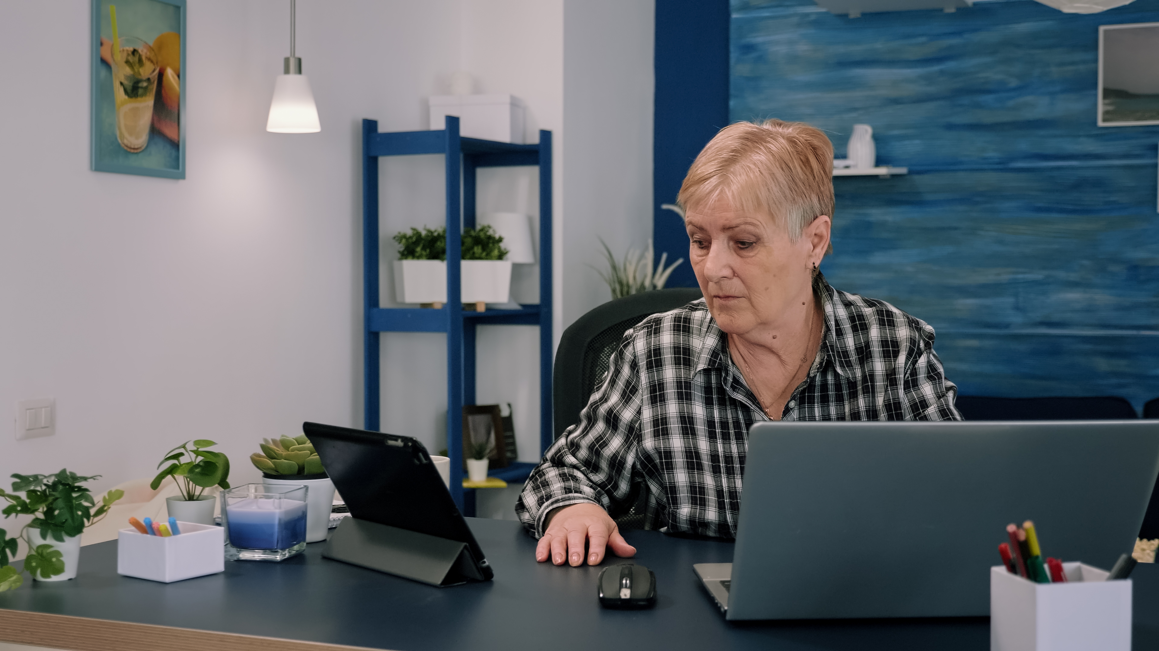 Ældre kvinde arbejder foran en computer